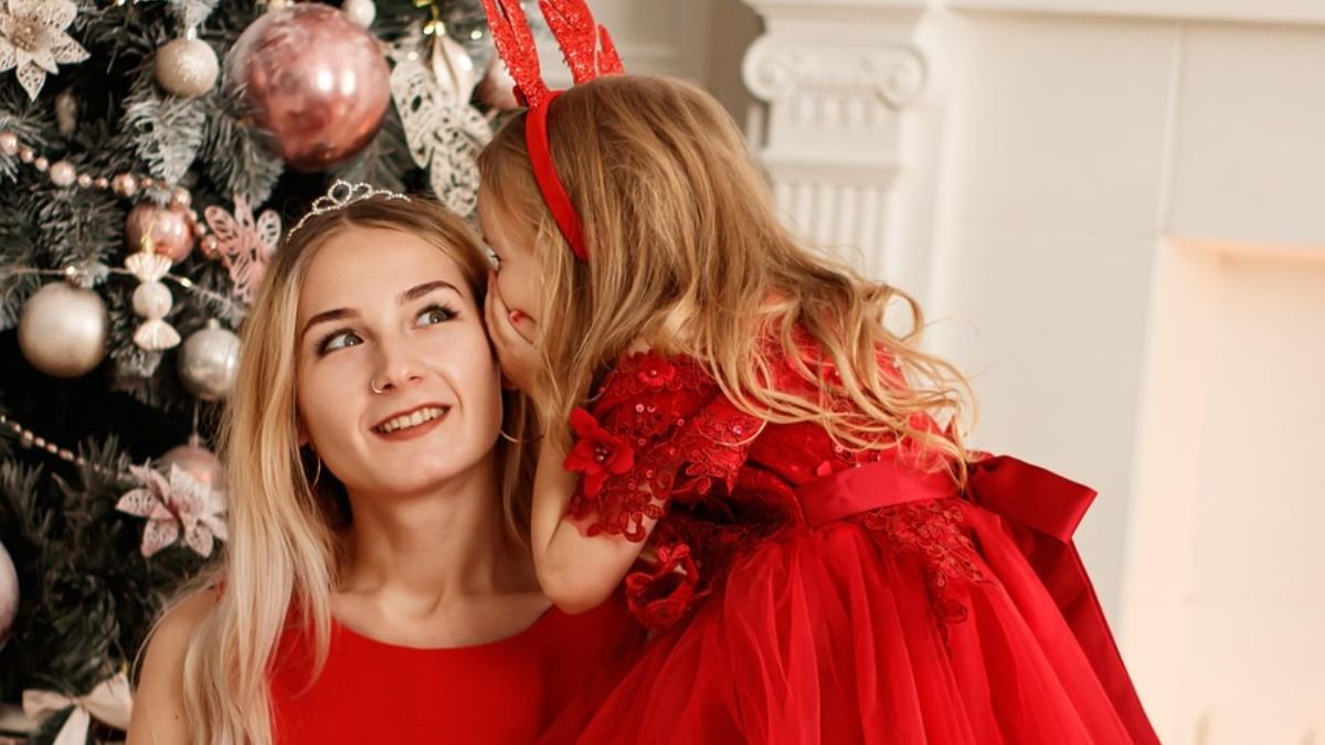 menina contando segredo para mae de vermelho